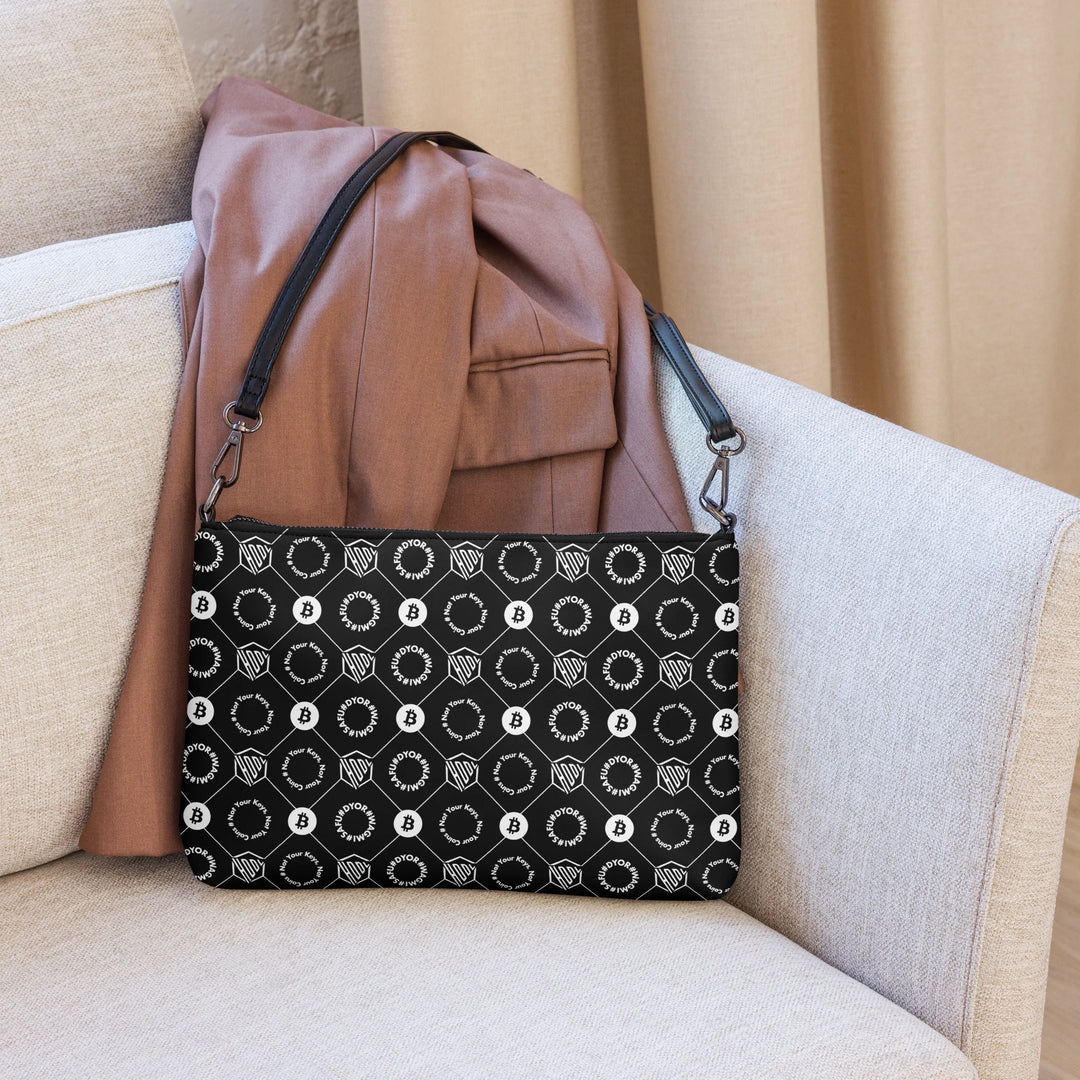 HODL Shoulder Bag "First Edition Black" on couch with brown jacket